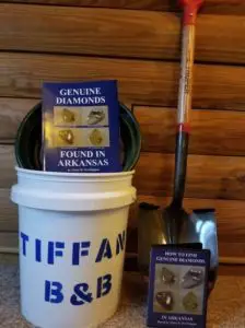 A white bucket labeled "TIFFAN B&B" holds guides on finding diamonds in Arkansas, alongside a shovel.