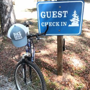 mountain bike and ball cap leaning against Guest Check In sign